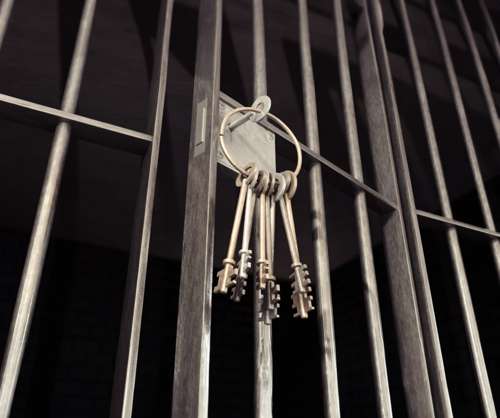 Image of a ring of jail keys with one inserted into a cell lock. Indicates release from jail.